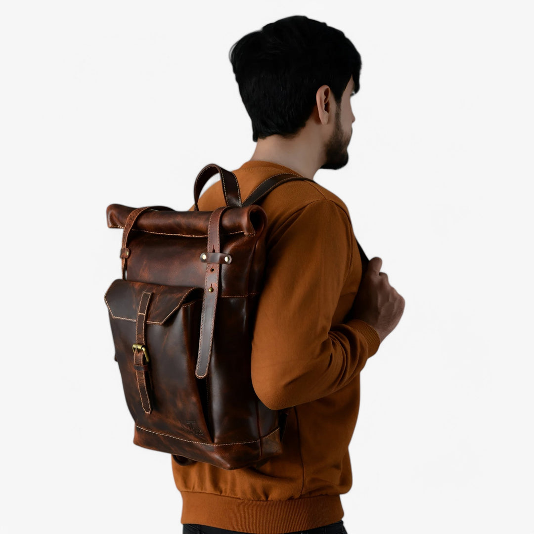Zaino roll top marrone unisex, vista laterale, fibbie regolabili in primo piano. Funzionale e robusto.