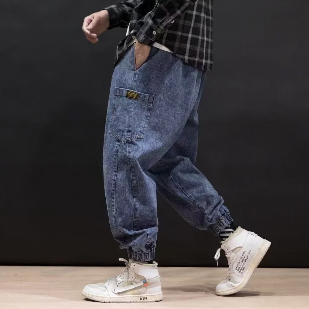 Jeans uomo a silhouette ampia con ricami dettagliati, relaxed fit e vita media, per uno stile streetwear distintivo.