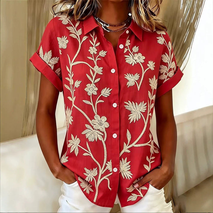 Top donna elegante a maniche corte, fantasia floreale. Ideale per outfit casual o serate estive.
