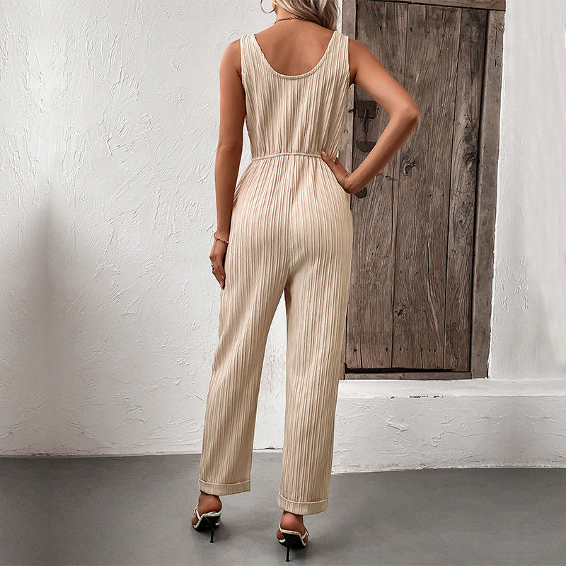Tuta donna chic beige, elegante e versatile, con cintura e pantaloni plissettati, ideale per ogni occasione.