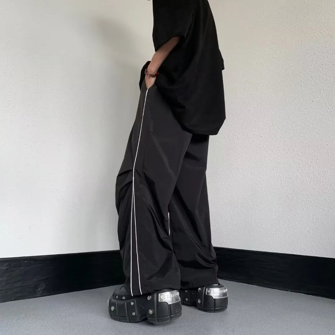 Dettaglio pantaloni uomo neri, gamba dritta. Design ampio e confortevole, ottimo per sport o casualwear.