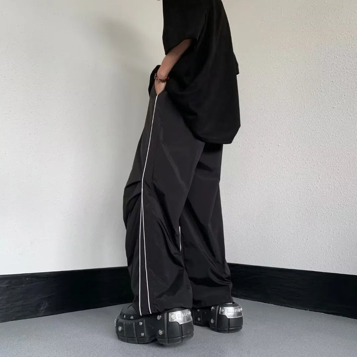 Dettaglio pantaloni uomo neri, gamba dritta. Design ampio e confortevole, ottimo per sport o casualwear.