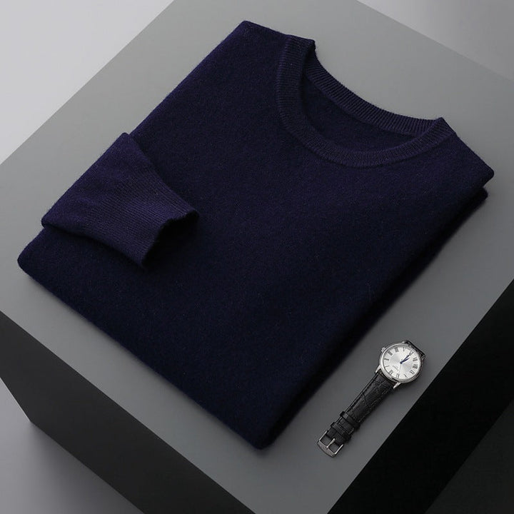 Uomo indossa pullover grigio scollo tondo, maniche lunghe, abbinato a jeans per un look casual autunnale.