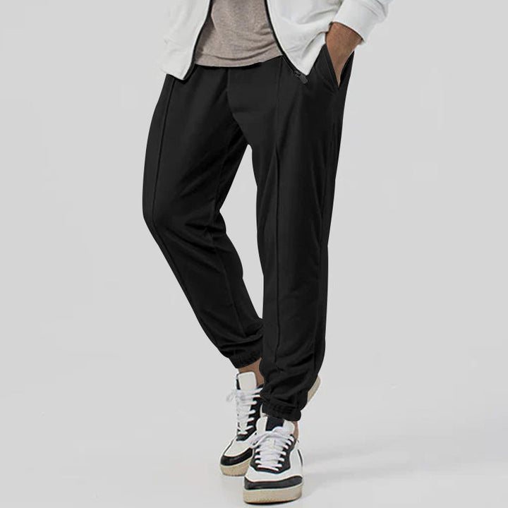 Pantaloni uomo streetwear, tuta vita media, tapered per relax e viaggio, comfort elevato.