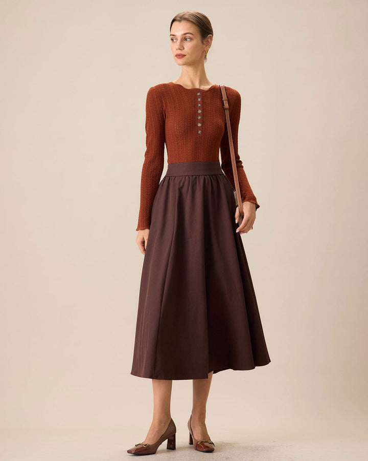 Maglione donna aderente marrone con scollo rotondo. Dettagli bottoni eleganti sulle maniche, perfetto per l'autunno.