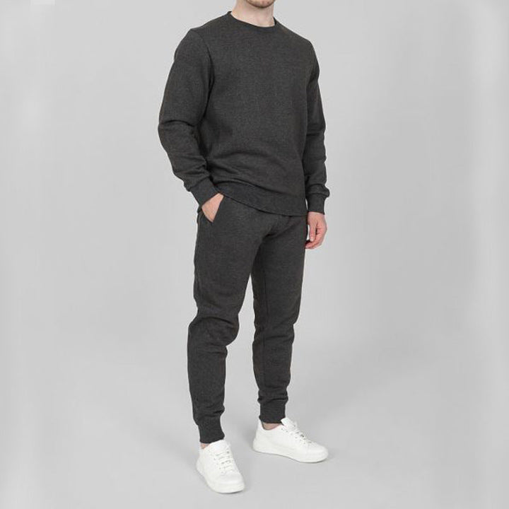 Uomo in tuta da running slim fit, ideale per fitness e corsa. Tessuto traspirante per massimo comfort in ogni stagione.