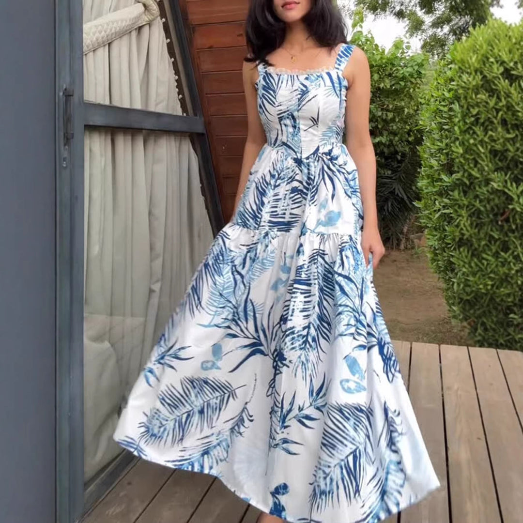 Elegante abito estivo lungo da donna blu, con stampa fluida e spalline sottili, perfetto per serate al mare.