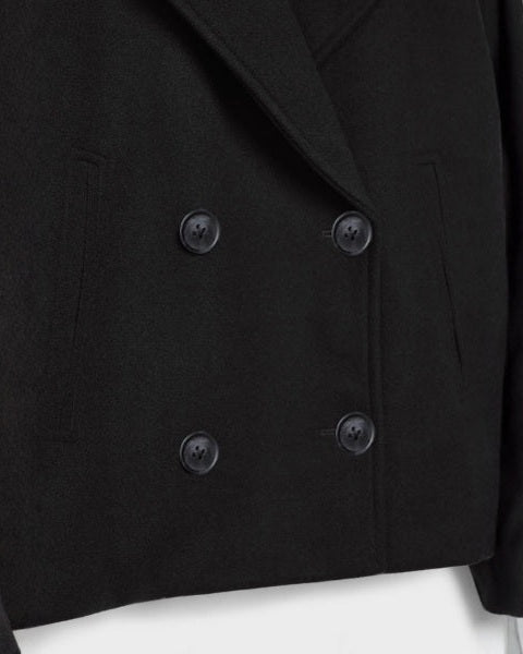 Cappotto donna minimal chic, corto doppiopetto, effetto lana, ideale per outfit eleganti autunno.