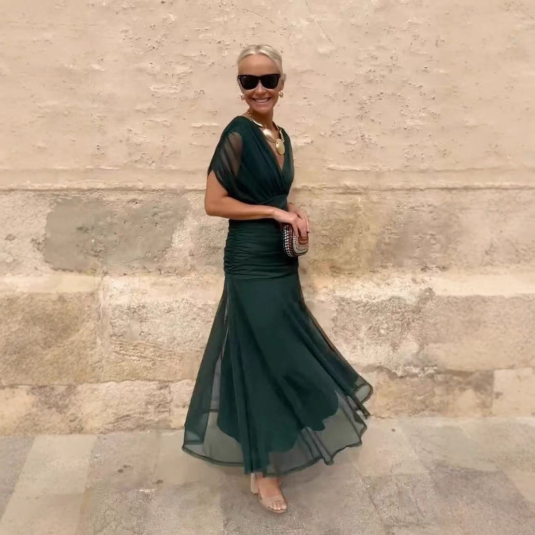 Abito cocktail nero con maniche trasparenti, scollo a V e vestibilità aderente per un look chic.
