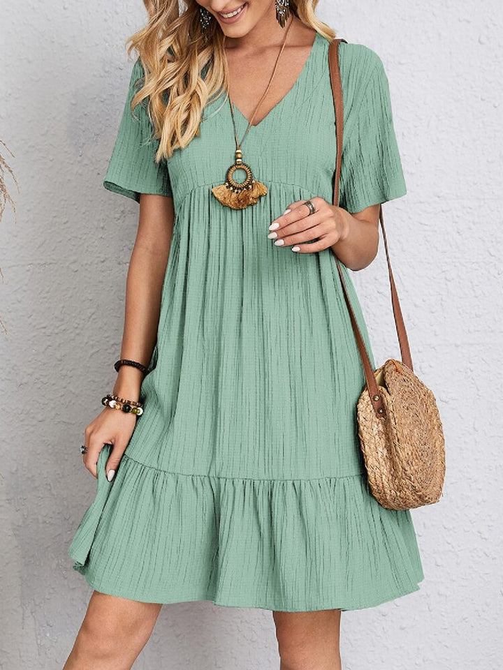 Abito elegante donna, vestito midi con dettagli stratificati. Moda primaverile estiva, look raffinato.