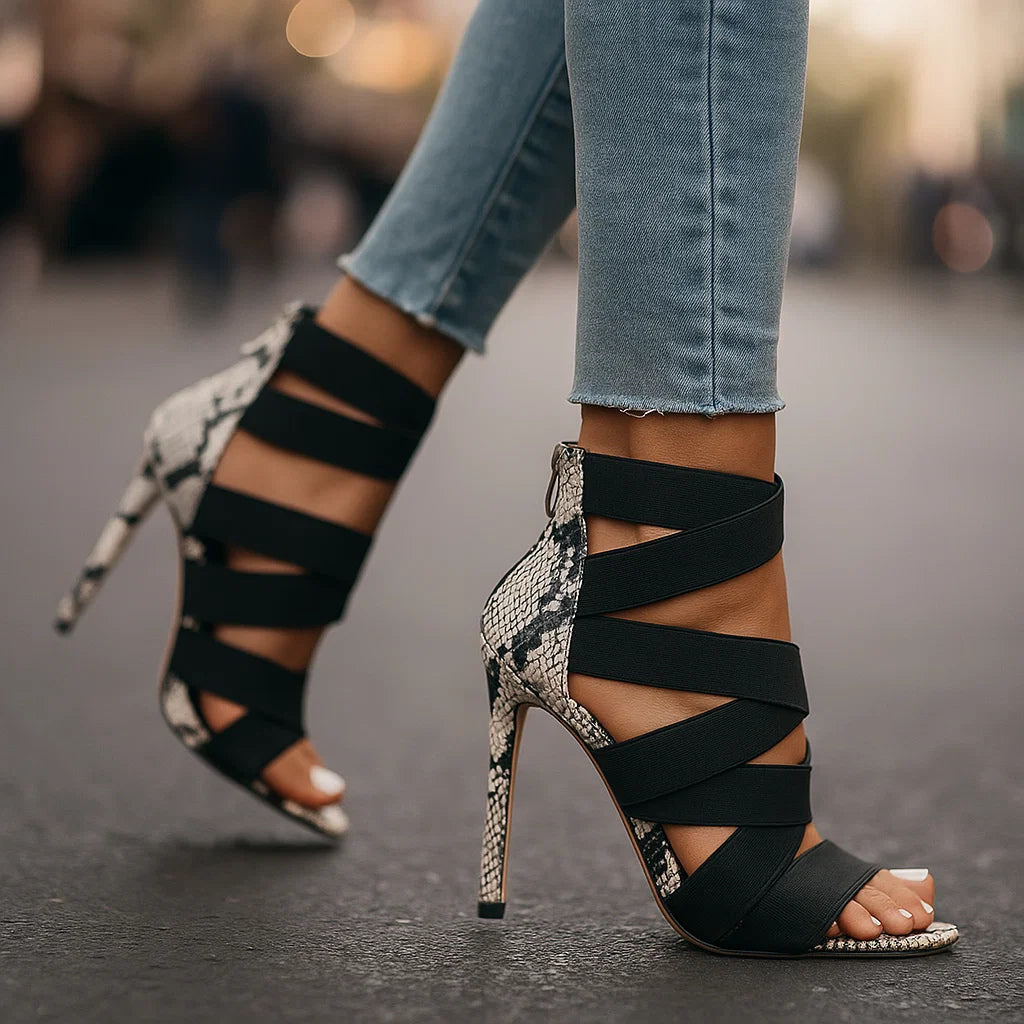 Décolleté donna con tacco a spillo stiletto, fasce elastiche effetto pitone. Scarpe eleganti e di tendenza.