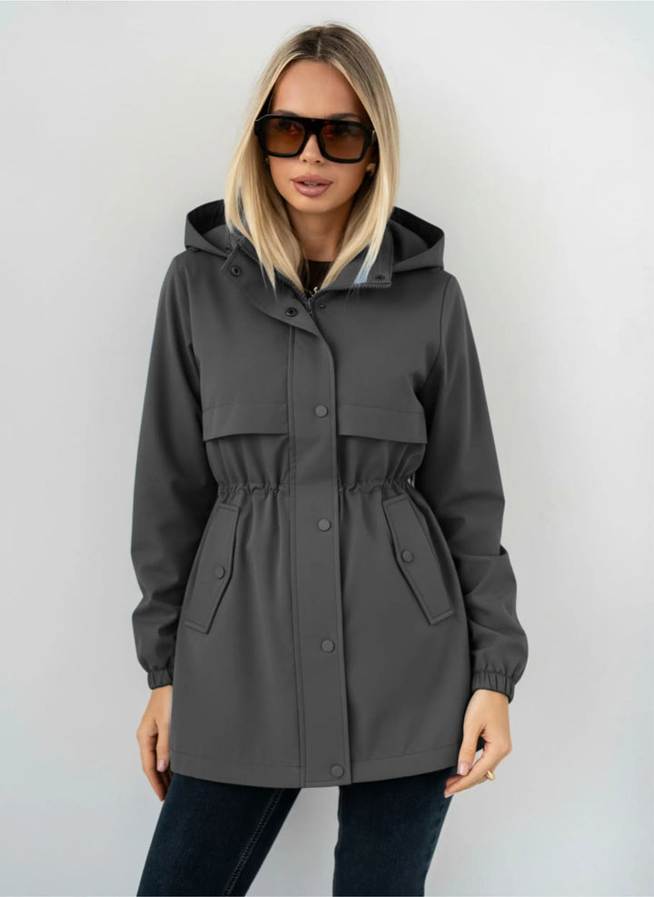 Donna cammina indossando giacca sportiva casual con cappuccio, comfort e stile per ogni giorno.