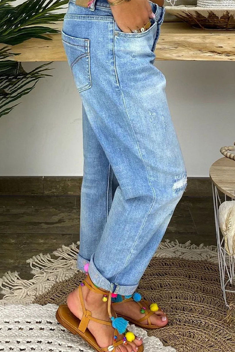 Jeans donna strappati a vita bassa, ideali per la moda streetwear. Tessuto confortevole, colore azzurro chiaro.