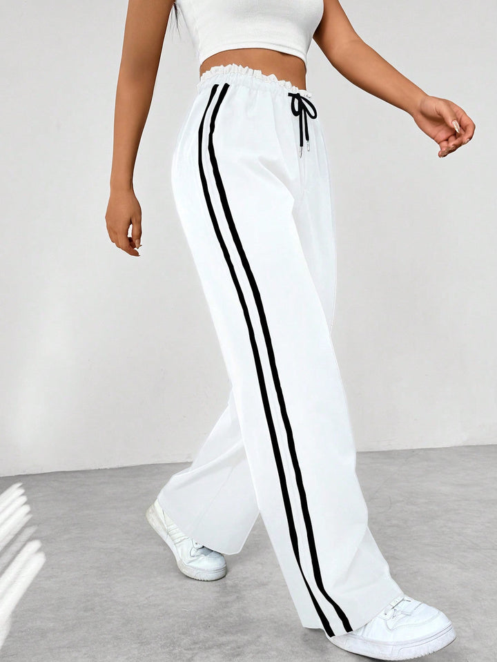 Donna in pantaloni sportivi a gamba larga, che evidenzia comfort, libertà di movimento e stile casual.