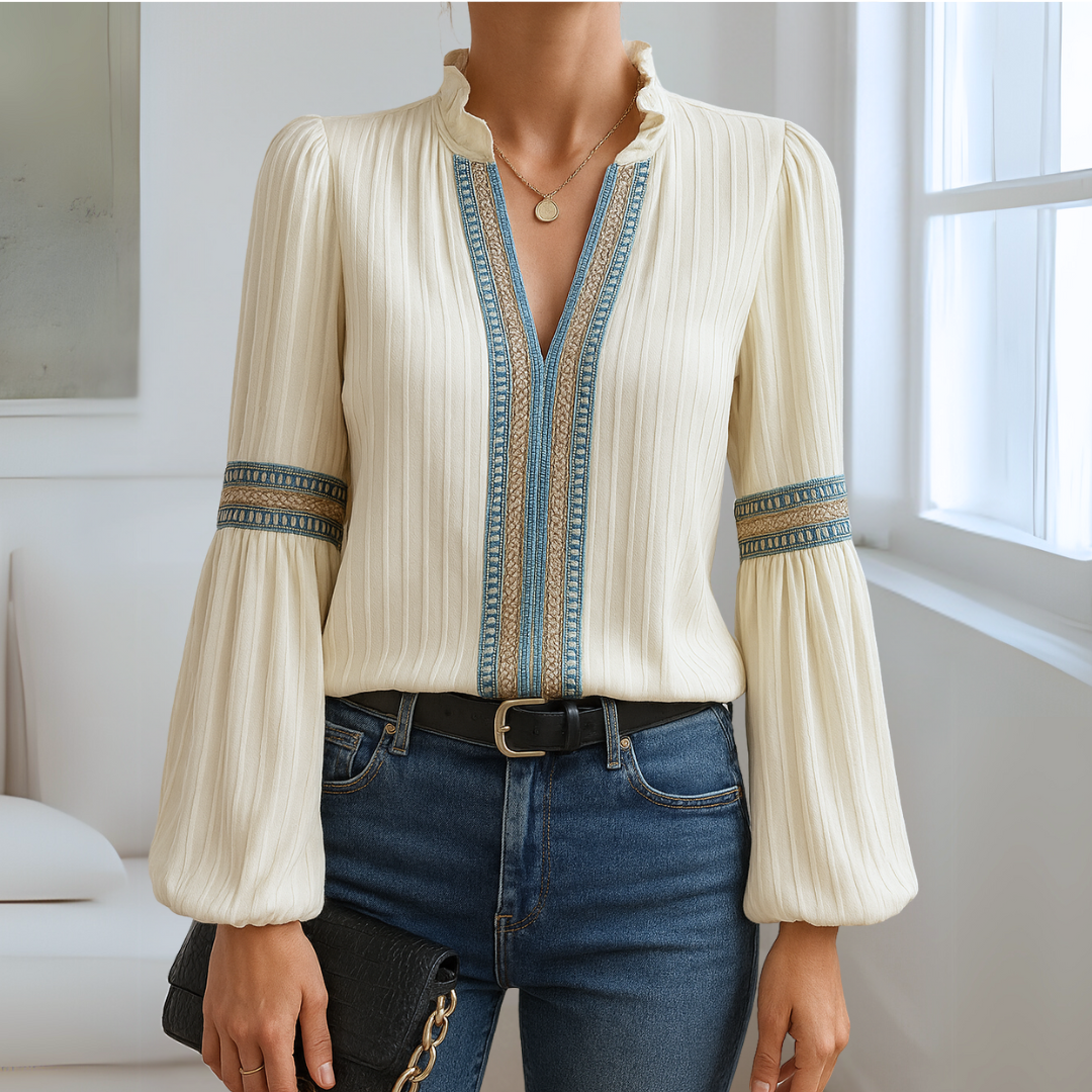 Elegante camicetta donna con scollo a V, maniche lunghe e dettagli in pizzo e volant. Moda femminile e chic.