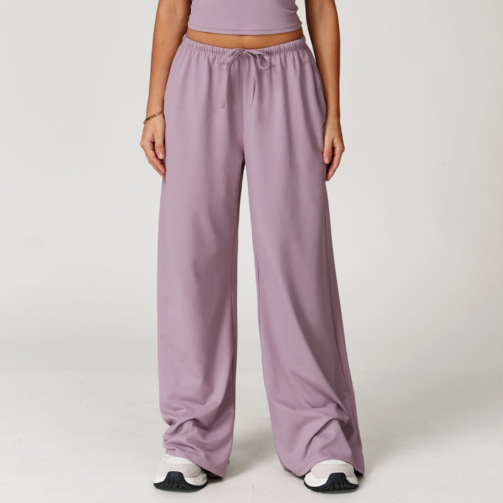 Pantaloni donna sportivi larghi, vita alta, ideali per comfort e stile casual. Con dettaglio pendente unico.