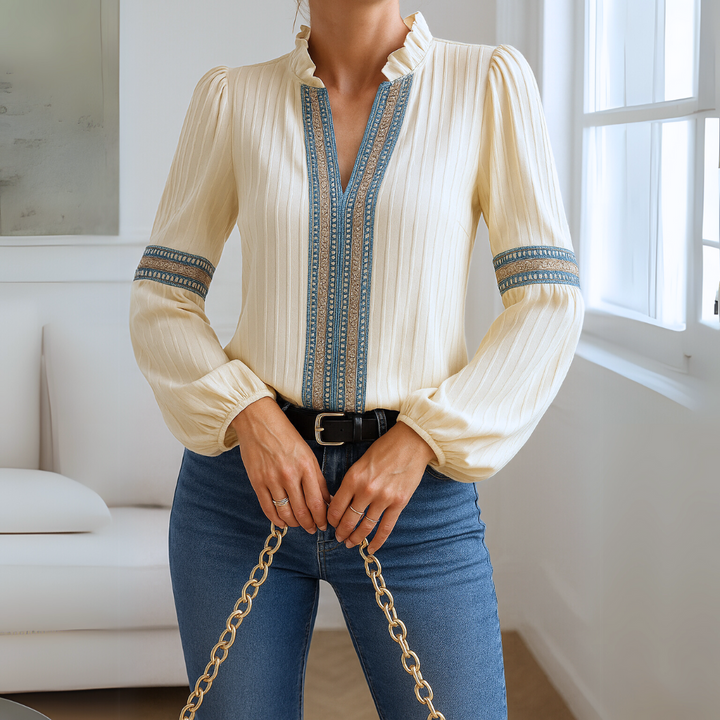 Camicetta donna elegante color crema con scollo a V, dettagli in pizzo e volant. Blusa femminile a manica lunga.