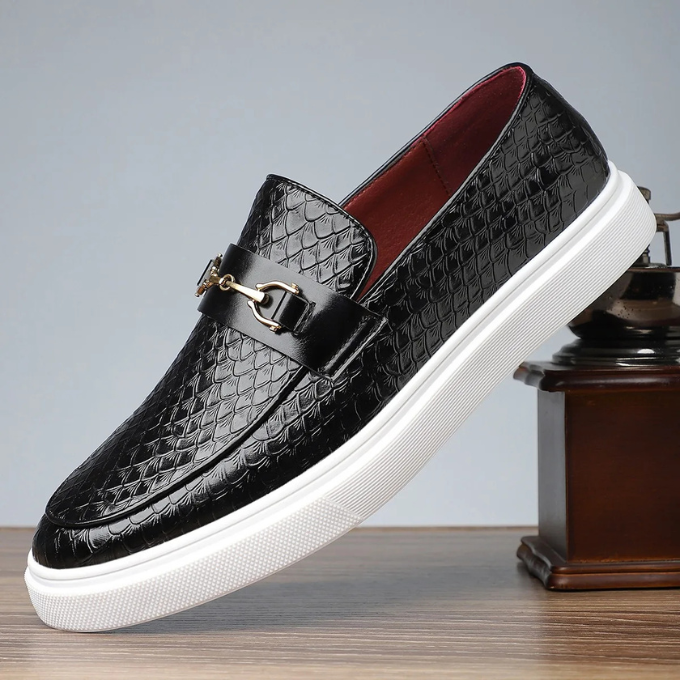 Mocassini uomo neri con fibbia metallica e texture effetto serpente. Eleganti e casual.