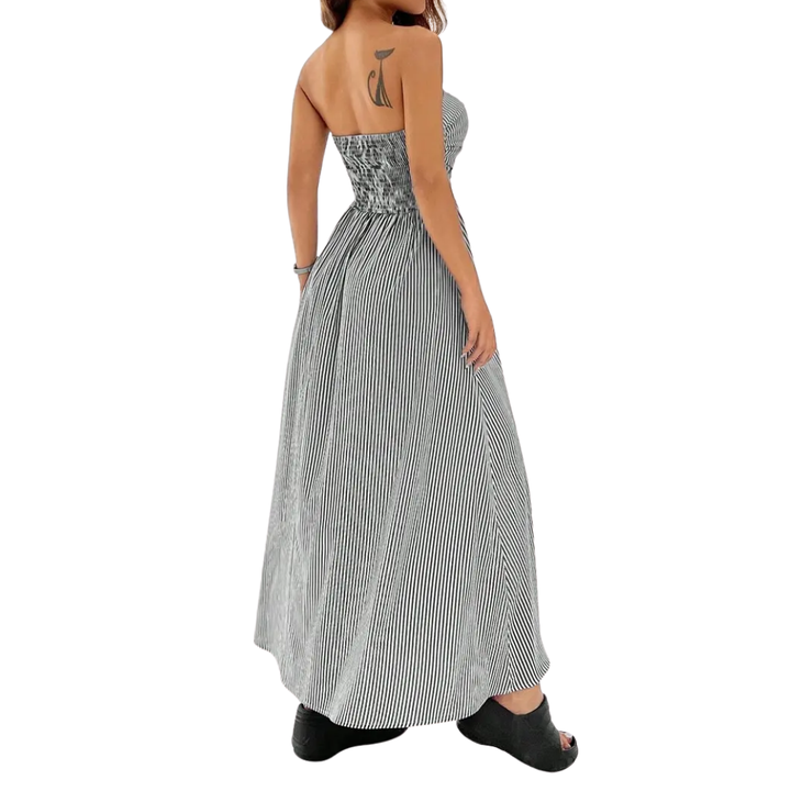 Abito maxi donna a righe trendy, scollo senza spalline e tasche. Versatile per un outfit da giorno o una serata estiva.