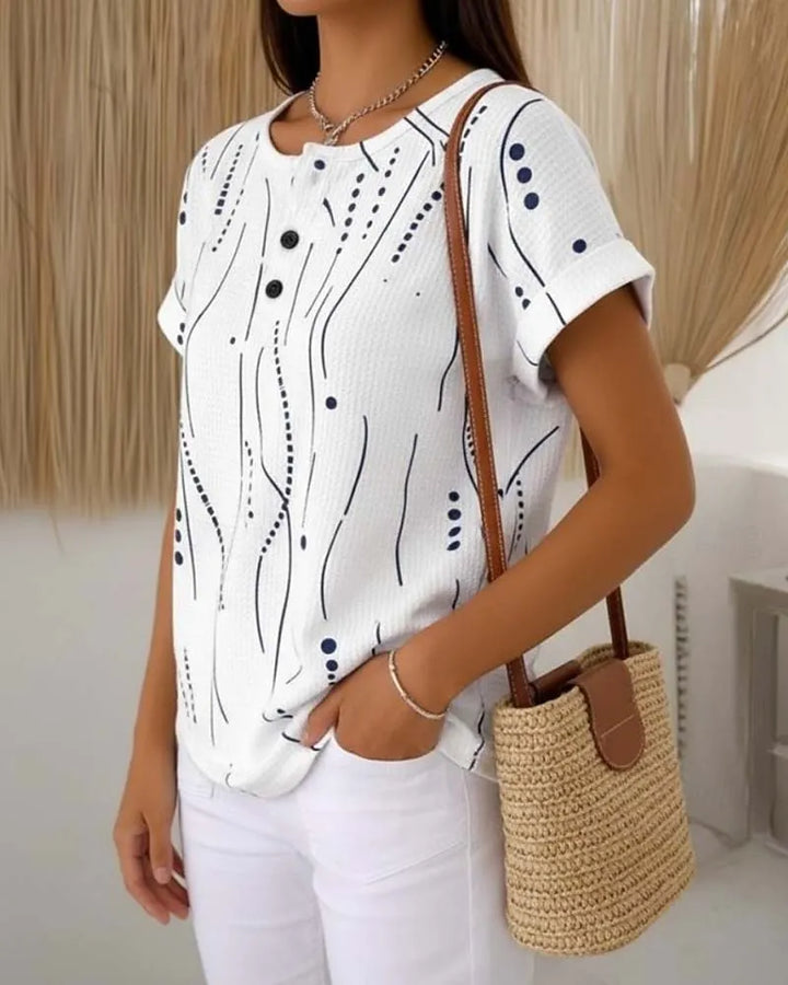 T-shirt donna rosa casual con stampa grafica e bottoni decorativi. Perfetta per comfort estivo e moda femminile.