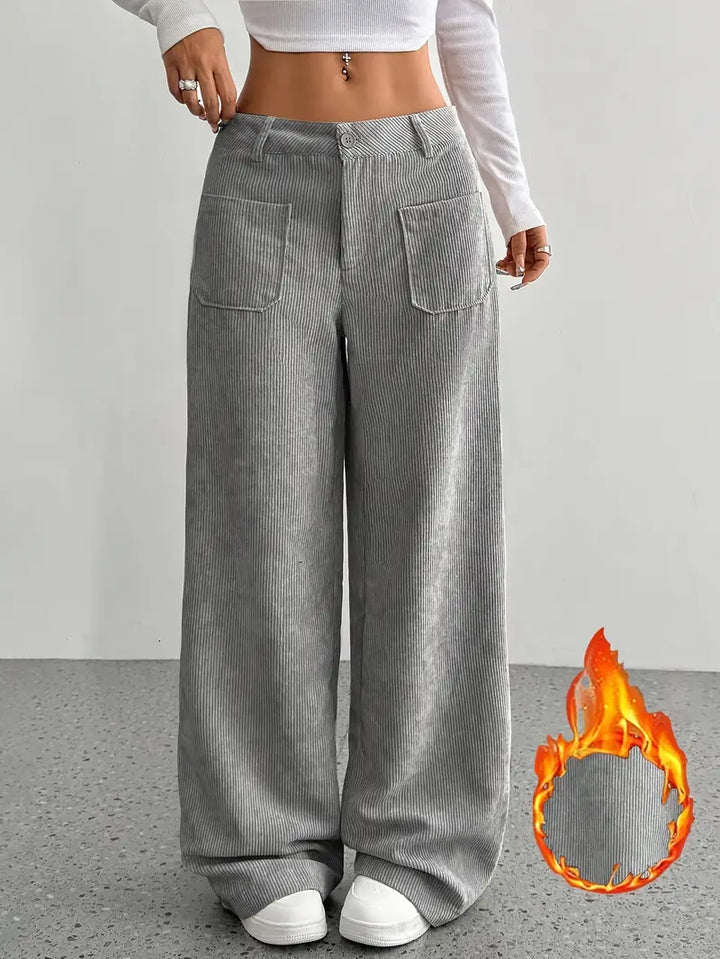 Profilo di donna in pantaloni a coste con vita alta e gamba ampia, look casual chic.