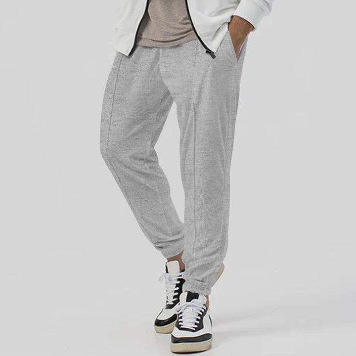 Pantaloni uomo tapered, tuta streetwear con gamba affusolata, vita media, per comfort e stile.