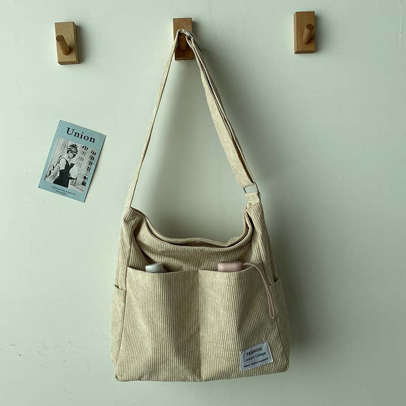 Elegante borsa donna in velluto a coste verde, accessorio moda versatile e retrò.