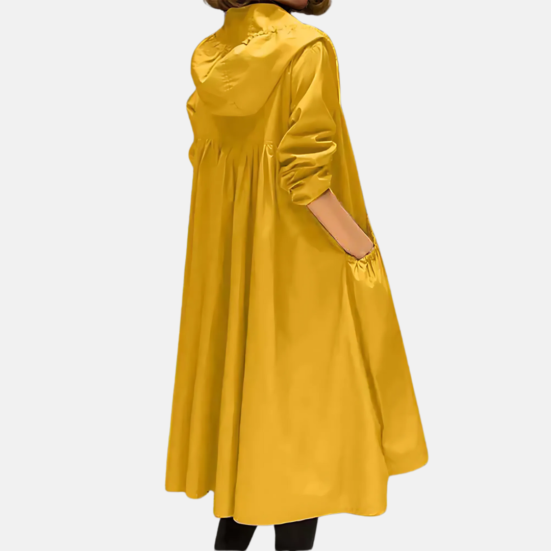 Moda donna: giacca impermeabile lunga al ginocchio con cappuccio, outerwear casual chic, ideale per giornate di pioggia.