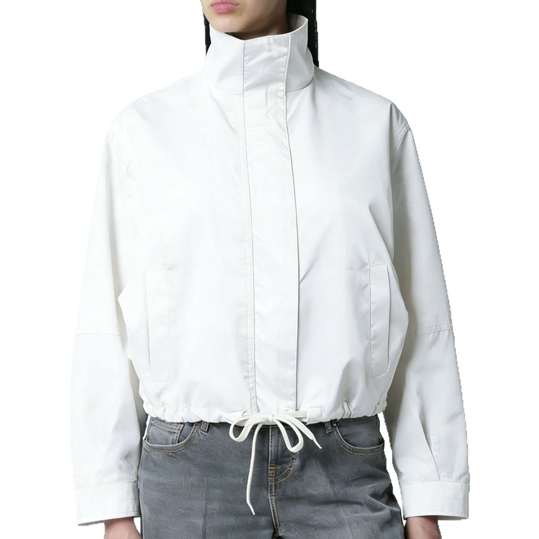 Donna indossa trench lungo elegante, ideale per look chic mezza stagione. Cappotto minimal con collo alto e maniche lunghe.