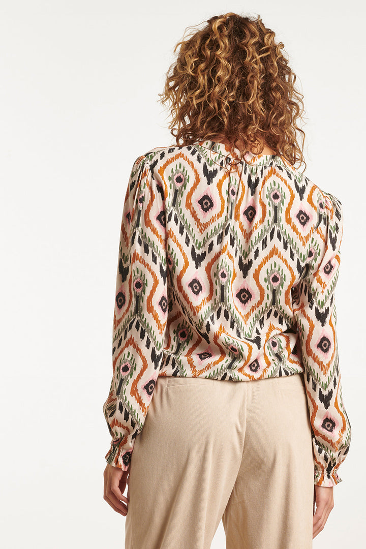 Moda femminile: top scollo a V, maniche lunghe. Blusa ampia con stampa tribale neutra. Perfetto per outfit casual.