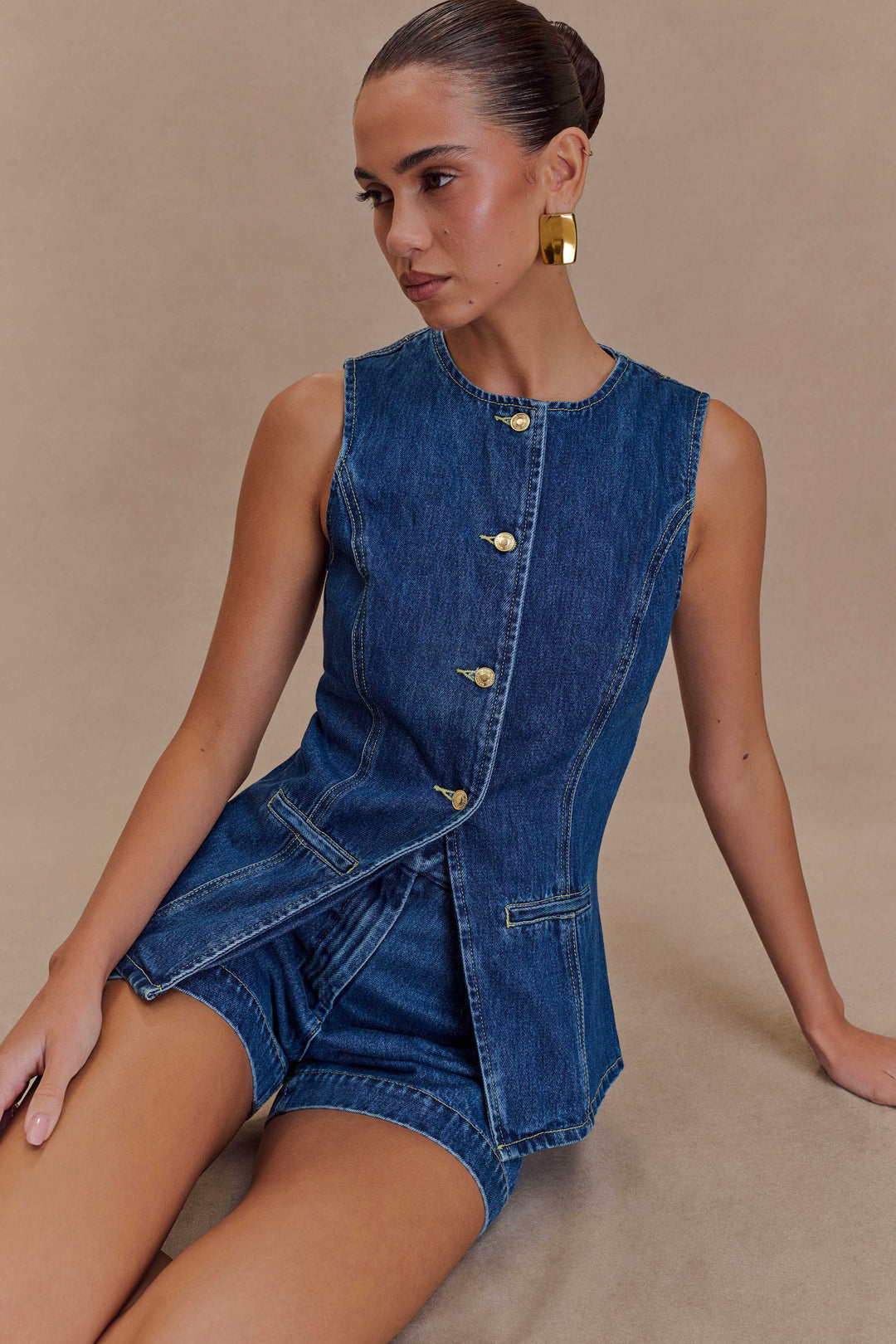 Moda estiva: completo donna due pezzi con gilet e shorts in denim blu scuro. Look casual chic per l'estate.