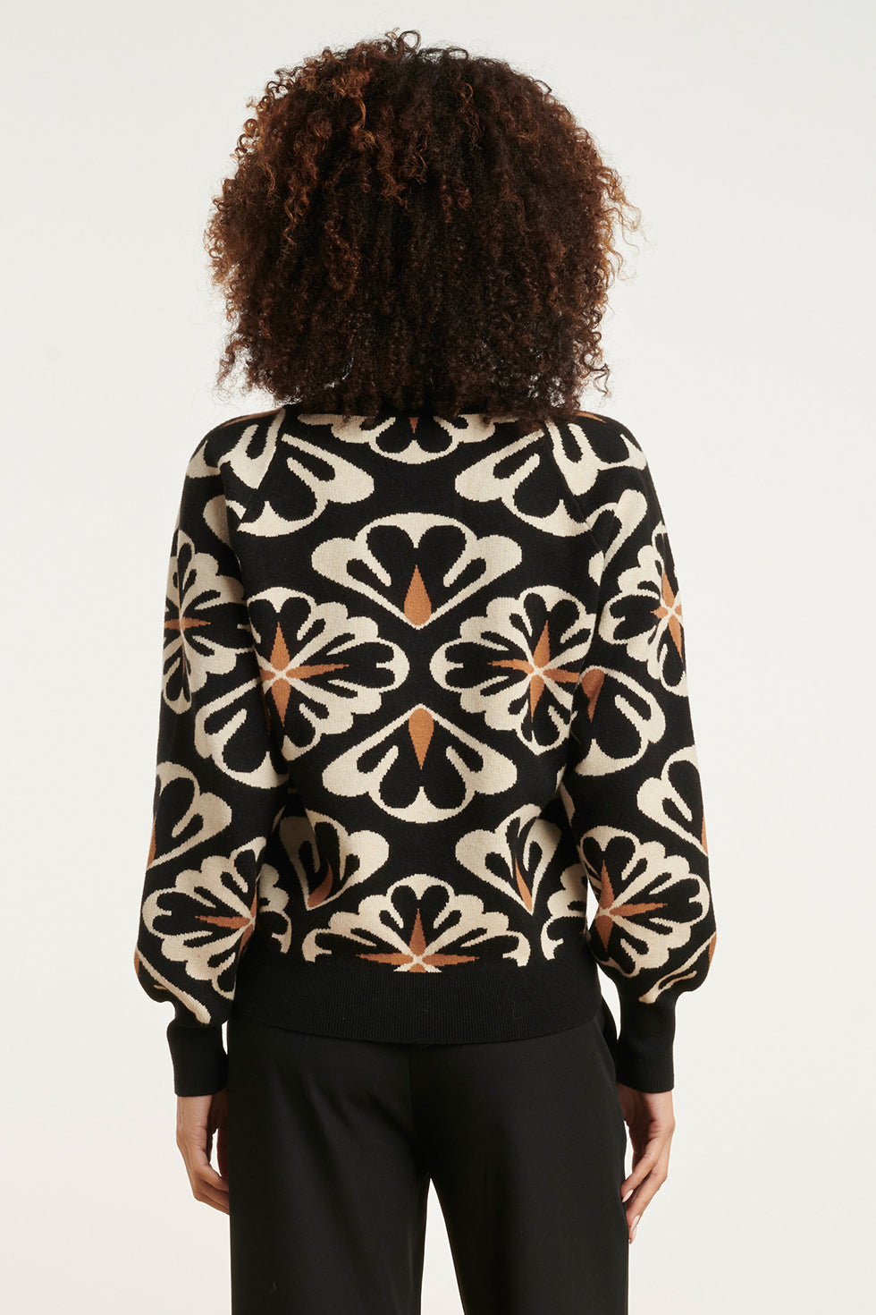 Dettaglio stampa floreale su maglione donna oversize nero con scollo a V, un tocco elegante e moderno.