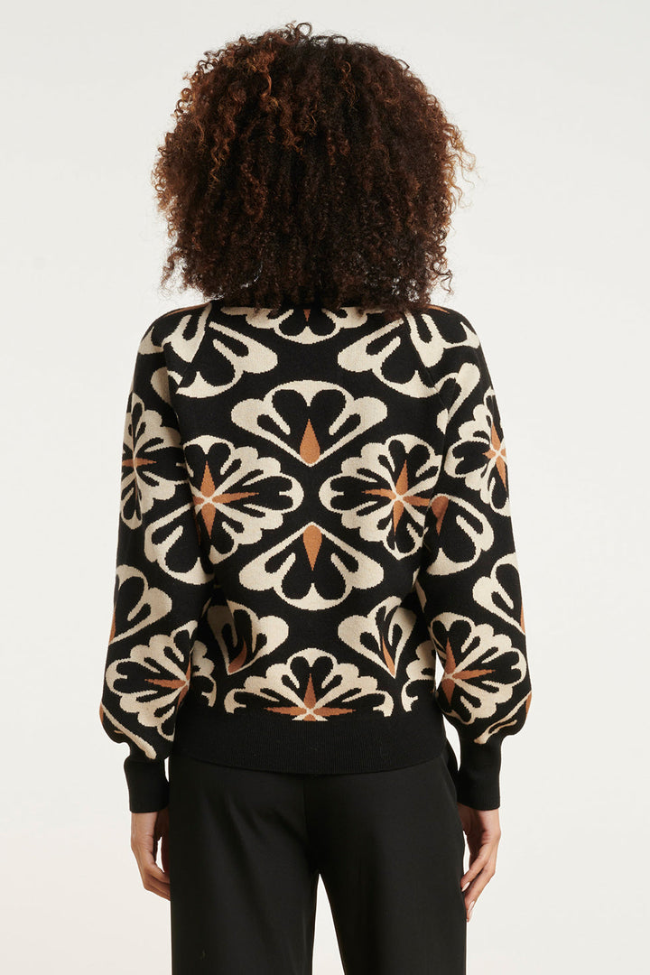 Dettaglio stampa floreale su maglione donna oversize nero con scollo a V, un tocco elegante e moderno.