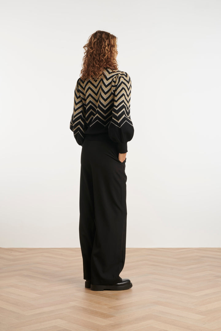 Camicia donna bianca e nera con stampa zigzag. Maniche a sbuffo e vestibilità ampia per comfort e stile.