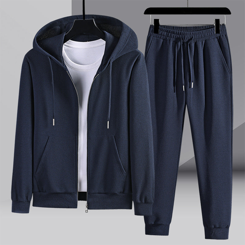 Comodo set sportivo uomo grigio con felpa a cappuccio e pantaloni nido d'ape. Ideale per relax e attività casual.
