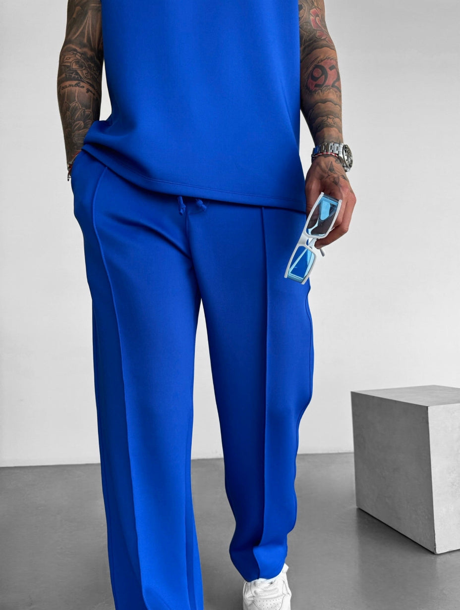 Completo versatile per uomo, top senza maniche e pantaloni sartoriali, ideale per relax e uscite.