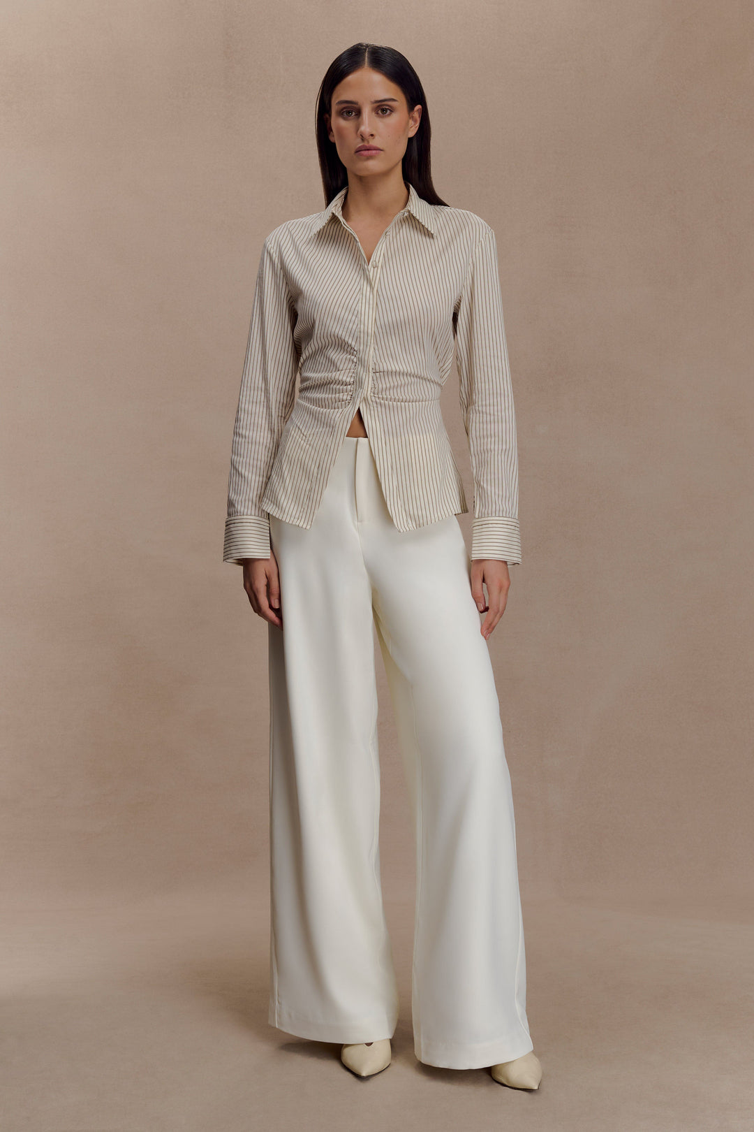 Camicia lunga da donna beige a righe sottili, vita arricciata. Eleganza e comfort per l'abbigliamento quotidiano.