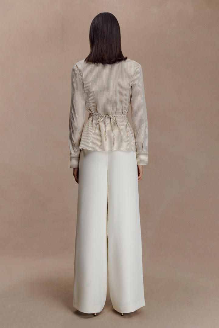 Dettaglio camicia donna beige, righe sottili verticali, vita arricciata. Un capo chic per ogni occasione.