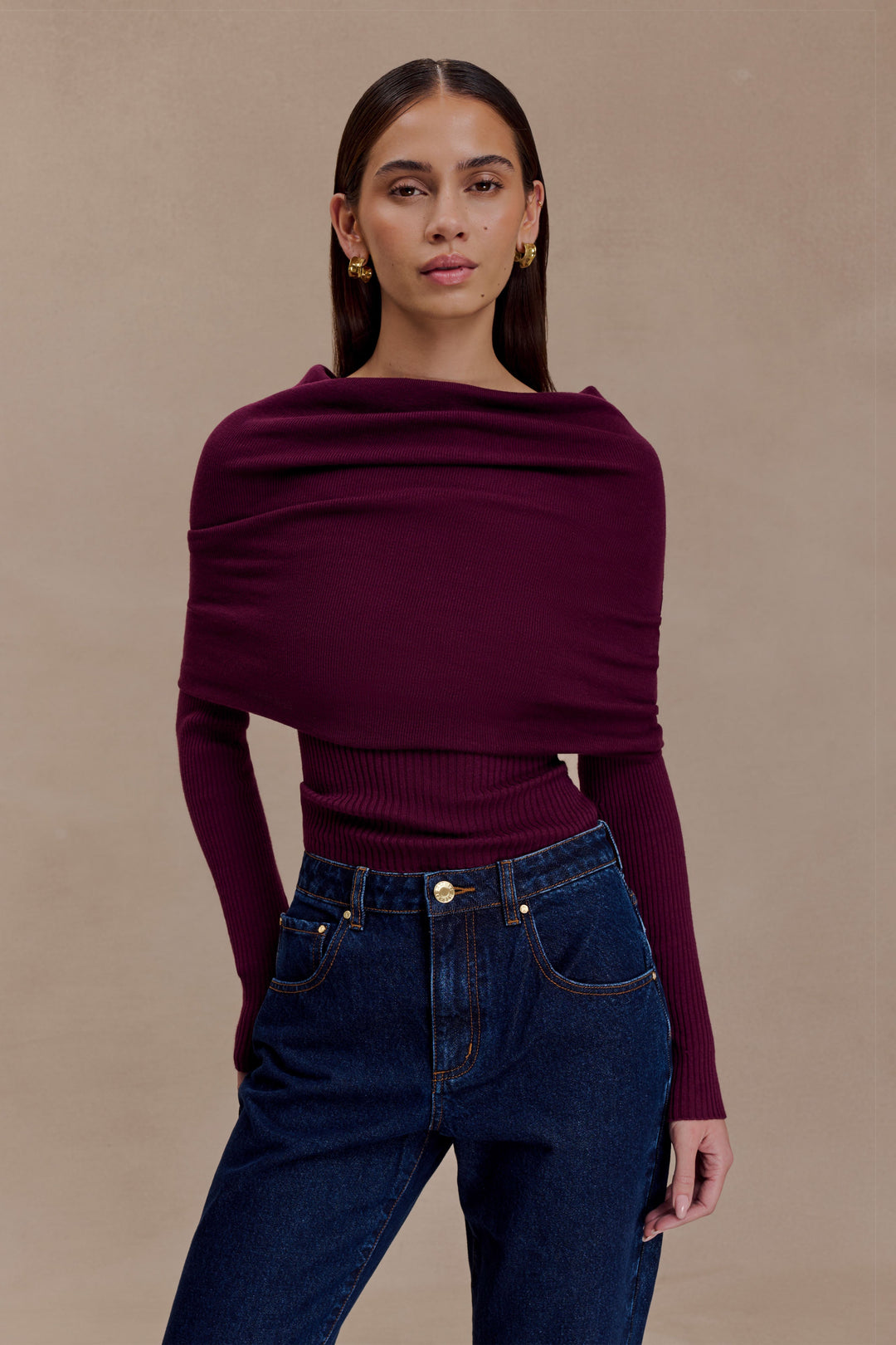 Top donna bordeaux con scollo asimmetrico che scopre una spalla, collo alto. Pullover elegante e alla moda.