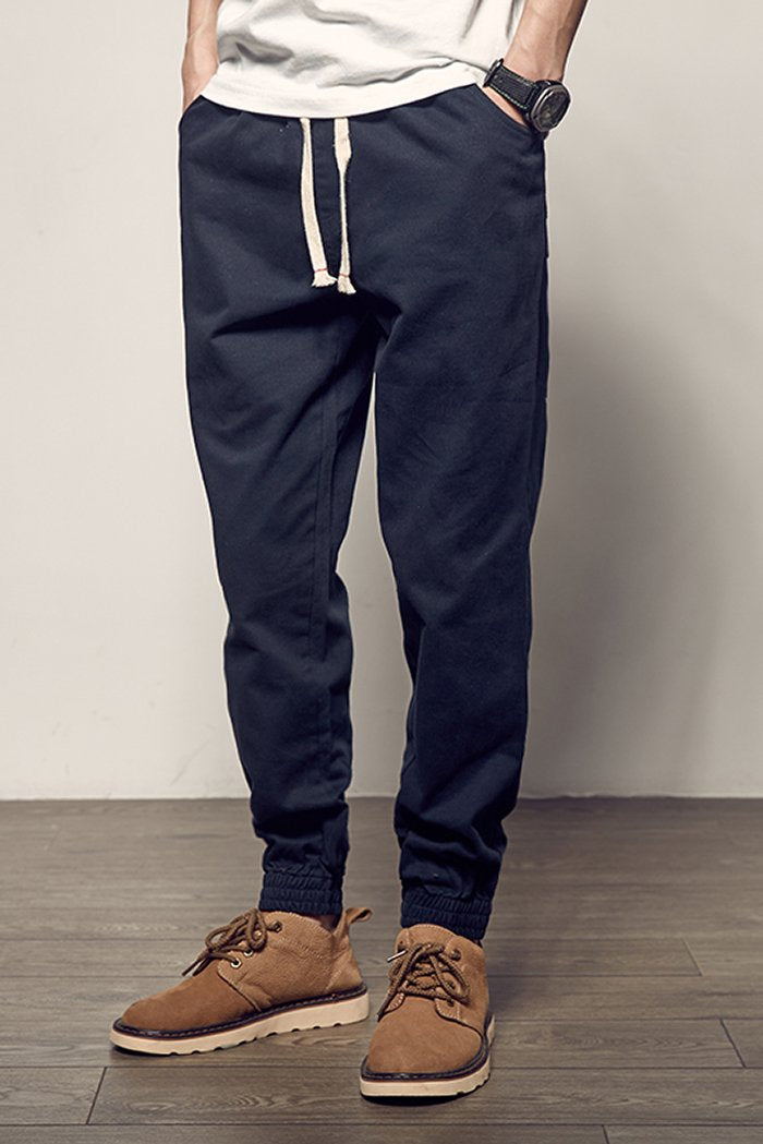 Uomo indossa pantaloni jogger casual in un ambiente urbano, perfetti per look streetwear, comfort e abbigliamento quotidiano.