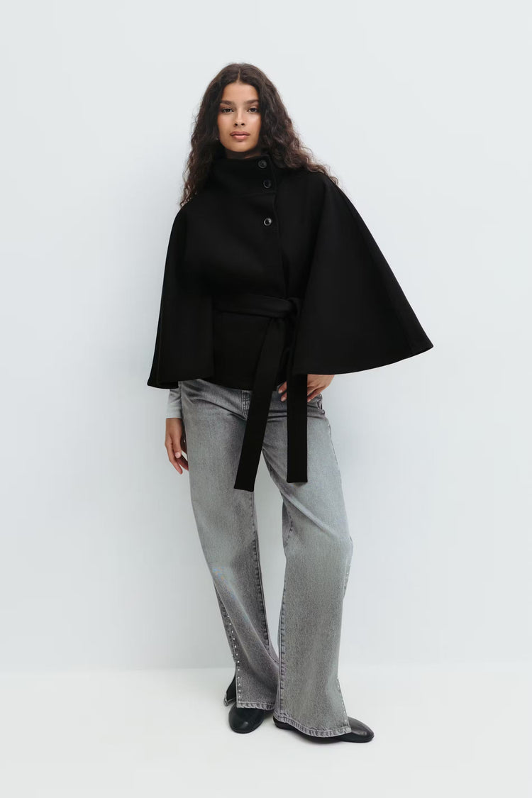 Cappotto a mantella chic per donna, stile moderno con collo alto e cintura raffinata.