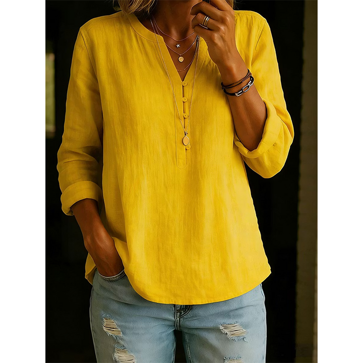 Dettaglio bottoni e collo a V su camicia donna ampia, maniche arrotolabili. Eleganza casual.