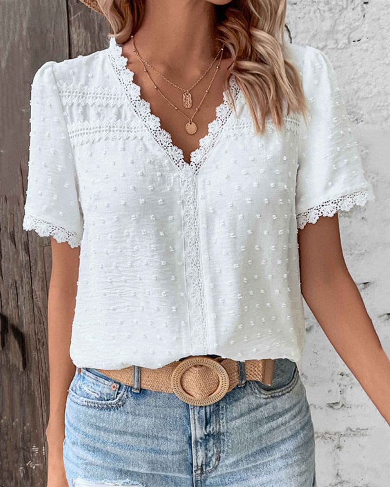 Camicetta bianca da donna romantica a maniche corte. Top leggero ed elegante per un look estivo quotidiano.