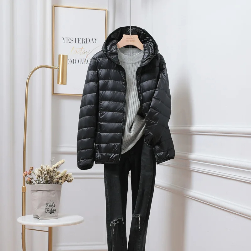 Elegante giacca trapuntata nera da donna con cappuccio, leggera. Essenziale per l'inverno.