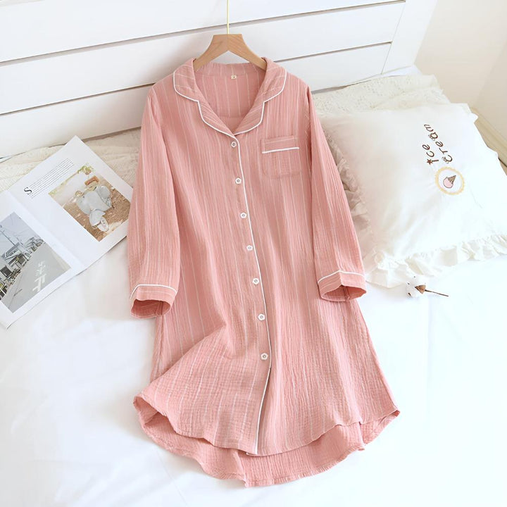 Donna che indossa camicia da notte a righe, confortevole e rilassante, perfetta per serate primaverili/estive.