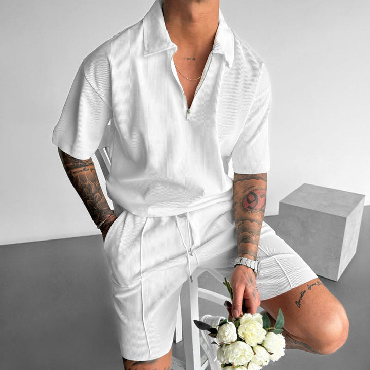 Uomo che indossa completo sportivo casual: polo con zip e pantaloncini, ideale per il relax estivo.