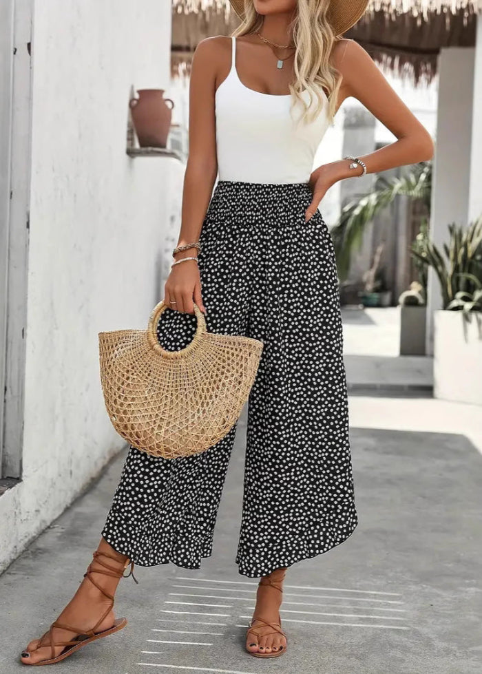 Alla moda pantaloni a pois da donna, modello palazzo a gamba larga e vita alta. Look fresco per la primavera estate.