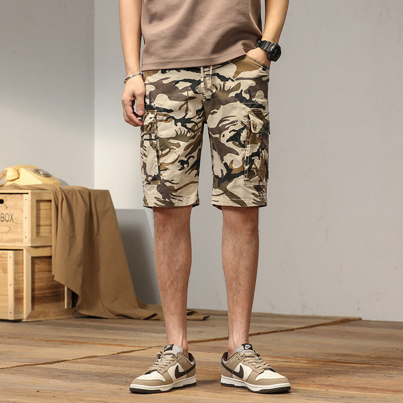 Uomo indossa bermuda cargo camouflage per look casual estivo, con tasche utility laterali, perfetti per la città.