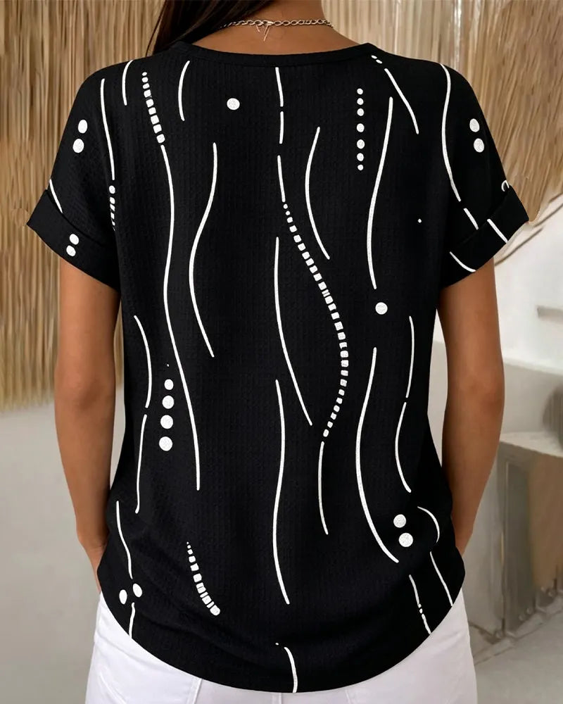 Modella indossa t-shirt donna casual con bottoni e stampa grafica. Perfetta per outfit primavera estate.