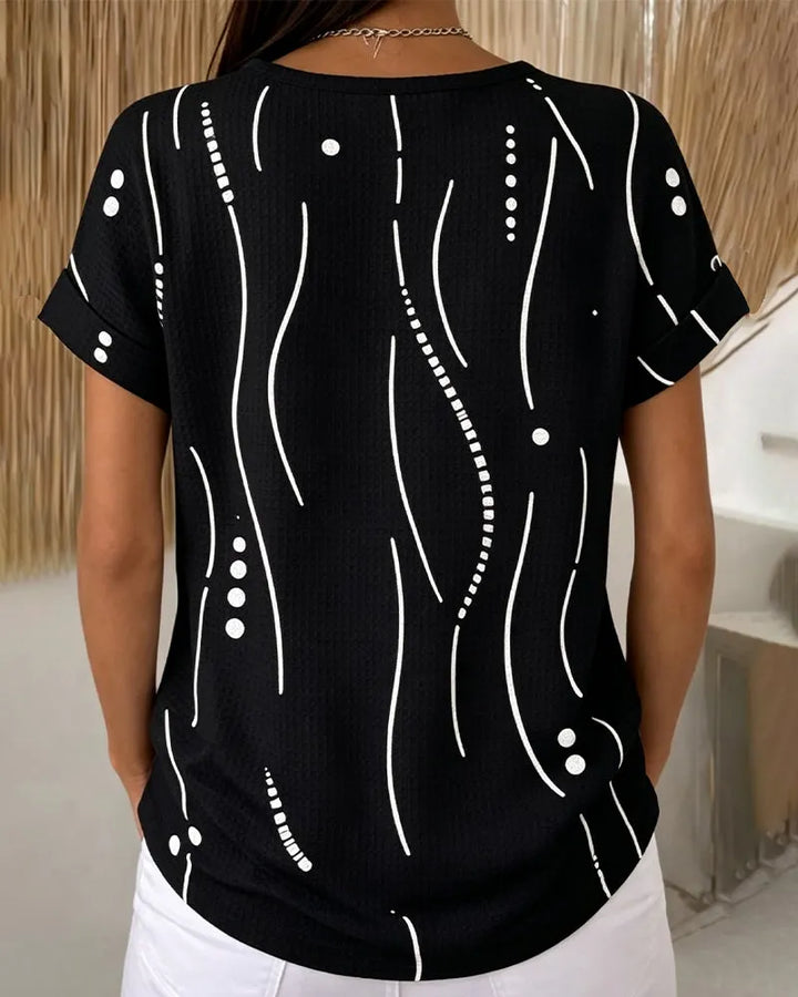 Modella indossa t-shirt donna casual con bottoni e stampa grafica. Perfetta per outfit primavera estate.